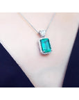 GIA certified 5.65 ct. medium-deep green Colombian emerald pendant with halo diamonds on an 18K white gold chain.