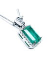 GIA certified 5.65 ct Colombian emerald pendant with medium-deep green emerald-cut gem and diamond halo in 18K white gold.