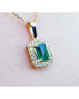 0.75 ct. GIA certified F1 Colombian emerald pendant with diamond halo in 18k yellow gold.
