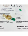 0.75 ct. GIA certified F1 Colombian emerald pendant in 18k gold with diamond halo, next to a loose emerald and GIA report.