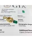 0.75 ct. GIA certified F1 Colombian emerald pendant in 18k gold with diamond halo, next to a loose emerald and GIA report.