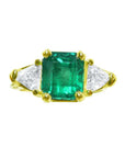 18K yellow gold ring with a GIA certified emerald and side trillion diamonds.