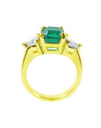 18K yellow gold ring with a GIA certified emerald and side trillion diamonds.
