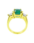 18K yellow gold ring with a GIA certified emerald and side trillion diamonds.