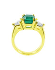 18K yellow gold ring with a GIA certified emerald and side trillion diamonds.