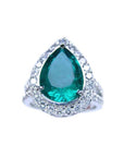 A GIA certified pear shaped natural colombian emerald ring for women with a halo of genuine diamonds in 18k white gold.