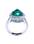 18K white gold ring with a large pear-shaped emerald surrounded by sparkling diamonds.