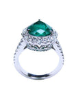 18K white gold ring with a large pear-shaped emerald surrounded by sparkling diamonds.