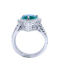 18K white gold ring with a pear-shaped deep bluish-green emerald surrounded by natural diamonds.