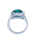 18K white gold ring with a large pear-shaped emerald surrounded by sparkling diamonds.