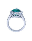 18K white gold ring with a large pear-shaped emerald surrounded by sparkling diamonds.