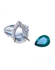 18K white gold ring setting with diamond halo next to a loose 4.02 ct pear-shaped deep bluish-green emerald.