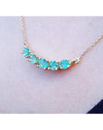 14K gold necklace with five sparkling round-cut medium light green Colombian emeralds.