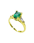 The tilted position of this emerald ring shows the top gemstone, side diamond and band profile.