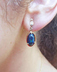 Ethiopian Welo black opal oval drop earrings with bluish-green and red-orange fire, set in 14K yellow gold.