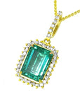 Gold pendant with a natural emerald and diamond accents on a white background.