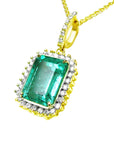Gold pendant with a square natural emerald and diamonds on a white background.