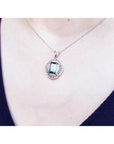 Watermelon tourmaline pendant necklace with emerald cut, bluish-green and pink stone, diamond accents, 14K white gold.