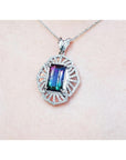 A natural bicolor tourmaline pendant in white gold and diamonds on a pink skin background.