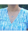 Ethiopian opal necklace pendant in 14K yellow gold, featuring a free-form cabochon with red and orange fire.