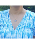 Ethiopian opal necklace pendant in 14K yellow gold, featuring a free-form cabochon with red and orange fire.