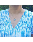 Ethiopian opal necklace pendant in 14K yellow gold, featuring a free-form cabochon with red and orange fire.