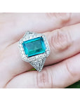 Anillo de oro blanco 18K con esmeralda colombiana rectangular de 3.98 ct. rodeada de diamantes.