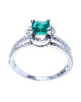 14K white gold engagement ring with a square emerald centerpiece and three rows of halo diamonds.