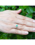 14K yellow gold ring with a medium green Colombian emerald in a tapered bezel, accented with natural diamonds.