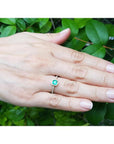 14K yellow gold ring with a medium green Colombian emerald in a tapered bezel, accented with natural diamonds.