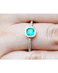 14K yellow gold ring with a 0.61 ct. medium green emerald in a tapered bezel, flanked by natural diamonds.