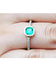 14K yellow gold ring with a 0.61 ct. medium green emerald in a tapered bezel, flanked by natural diamonds.