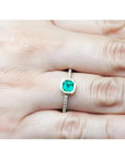 14K yellow gold ring with a medium green emerald in a tapered bezel, flanked by natural diamonds.