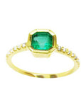 A medium green Colombian emerald ring bezel set with a tapered bezel set in a 14K gold band
