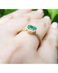 14K yellow gold ring with a 0.61 ct emerald in a tapered bezel and diamond-studded band.