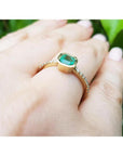 14K yellow gold ring with a 0.61 ct emerald in a tapered bezel and diamond-studded band.