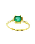 A medium green Colombian emerald ring bezel set with a tapered bezel set in a 14K gold band.