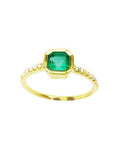 A medium green Colombian emerald ring bezel set with a tapered bezel set in a 14K gold band.