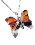 Agate butterfly-shaped pendant necklace with wings design on a silver chain against a white background.