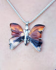 Agate butterfly pendant necklace in orange, brown, and black, set in sterling silver.