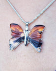 Agate butterfly pendant necklace in orange, brown, and black, set in sterling silver.
