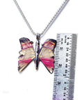 Handcrafted butterfly agate pendant necklace with rich pink wings and sterling silver chain, shown with ruler for size.