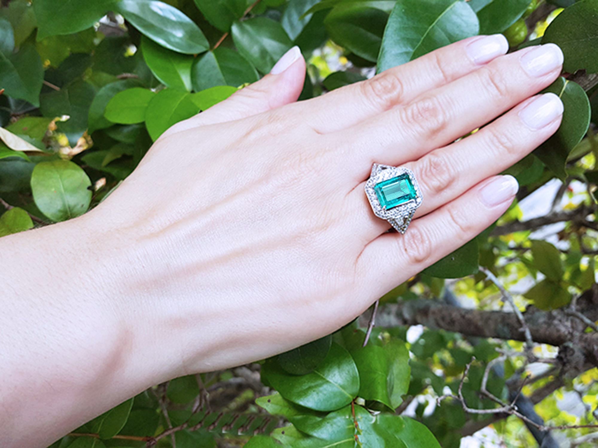 anillo de compromiso con esmeralda y diamantes laterales corte trillion