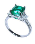 Anillo de compromiso con esmeralda corte cojín y diamantes trapezoides laterales