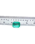 Vibrant medium green, emerald-cut 2.95 carat loose Colombian emerald next to a ruler.
