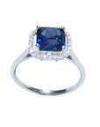 Asscher cut medium dark blue sapphire ring with halo diamonds in 18k white gold.