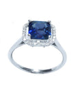Asscher cut medium dark blue sapphire ring with halo diamonds in 18k white gold.