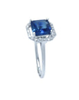 Asscher cut blue sapphire ring with halo diamonds in 18k white gold.