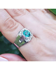 Men's 18K white gold ring with a vibrant bluish-green asscher-cut emerald and side diamonds.