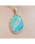 12.16 ct. Australian opal pendant with bluish-green play-of-color, set in 18K yellow gold.
